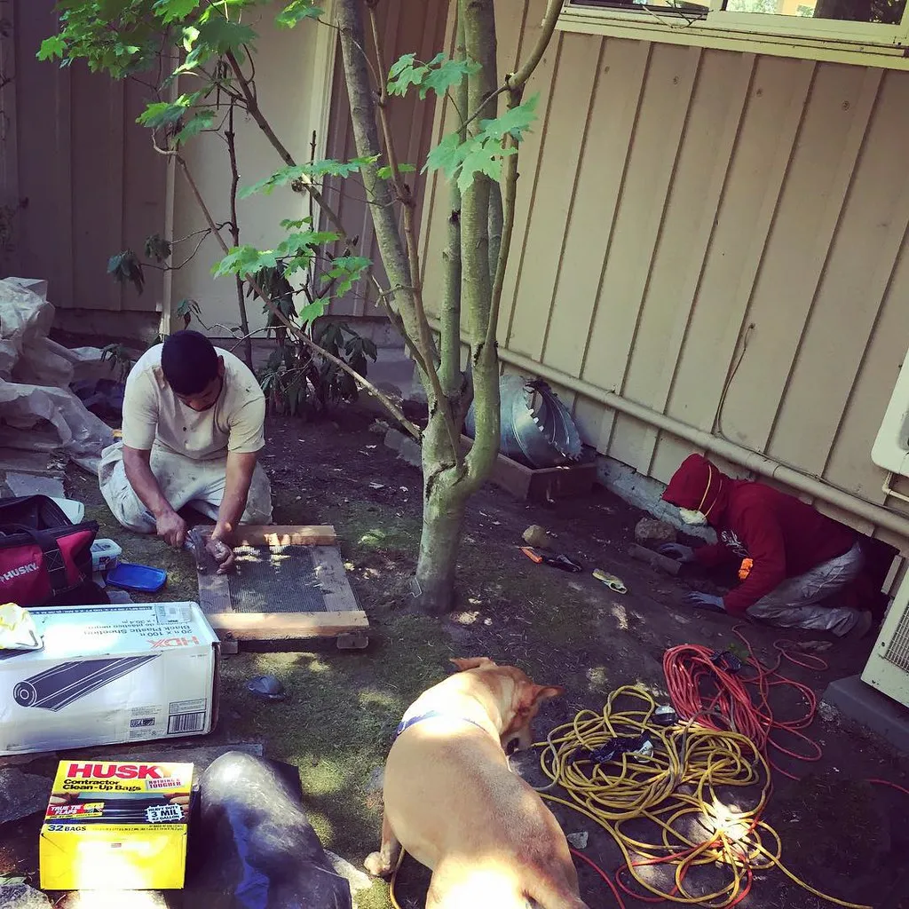 A crew clearing debris before a new vapor barrier goes into a crawl space