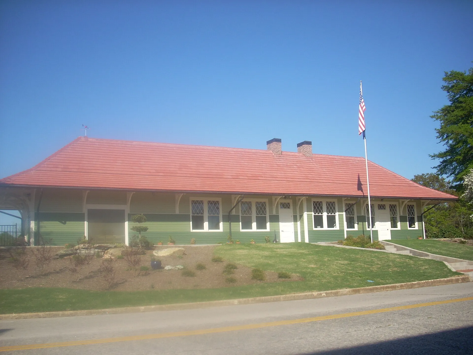 The Southern Railway passenger station in Westminster, a long green wooden depot with a red roof, white trim and a flagpole out front